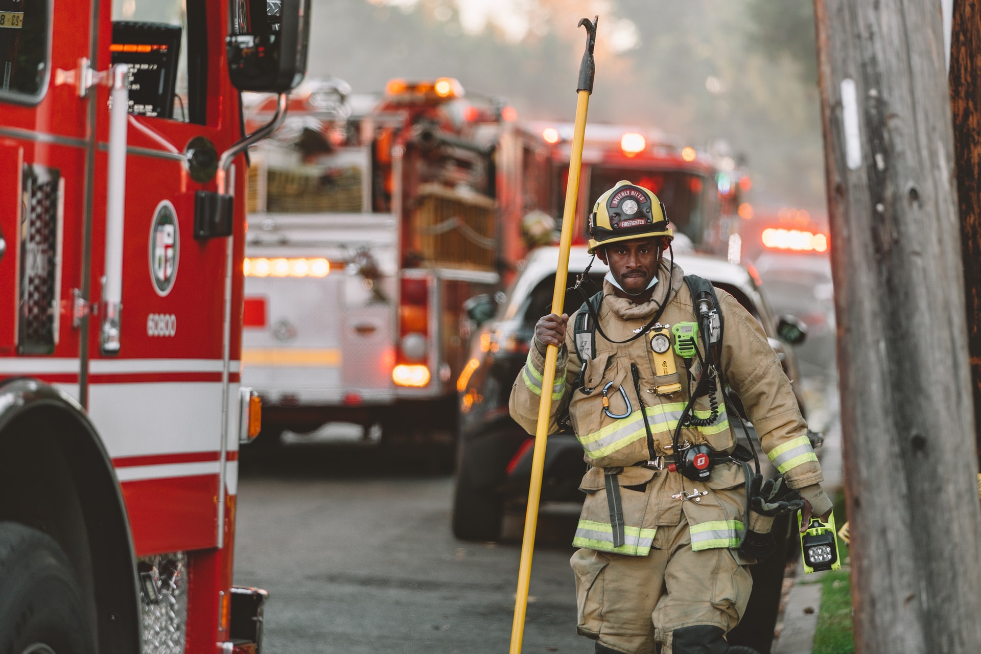 fire fighter with pole next to fire truck